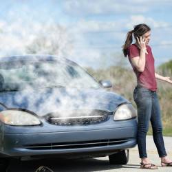 A teenage girl is broken down on the side of the road after car began to overheat