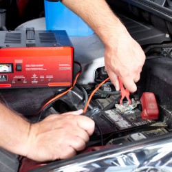 Battery charger and car in auto repair shop.