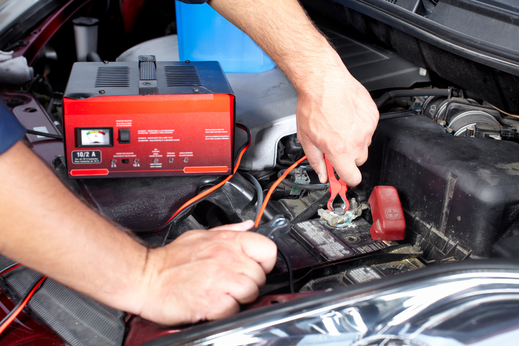 Battery charger and car in auto repair shop.